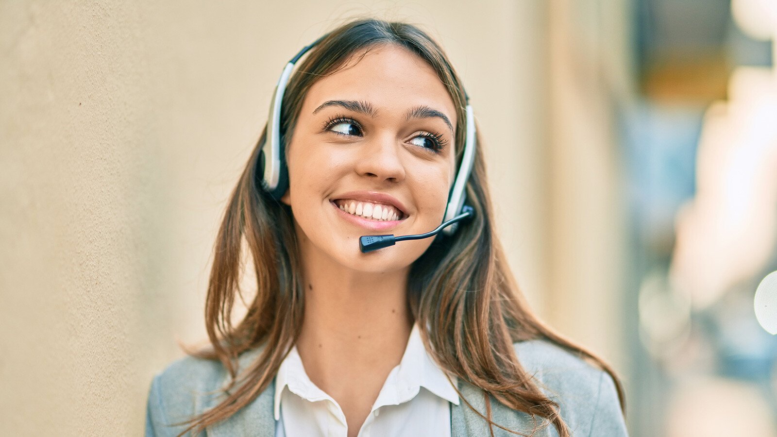 En ung dame som snakker i et headset på kontoret