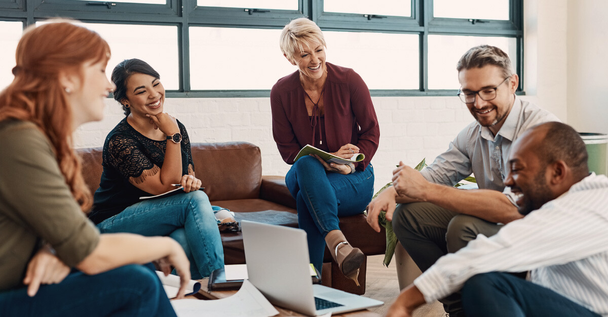 A group of people sitting at a cofee table working together